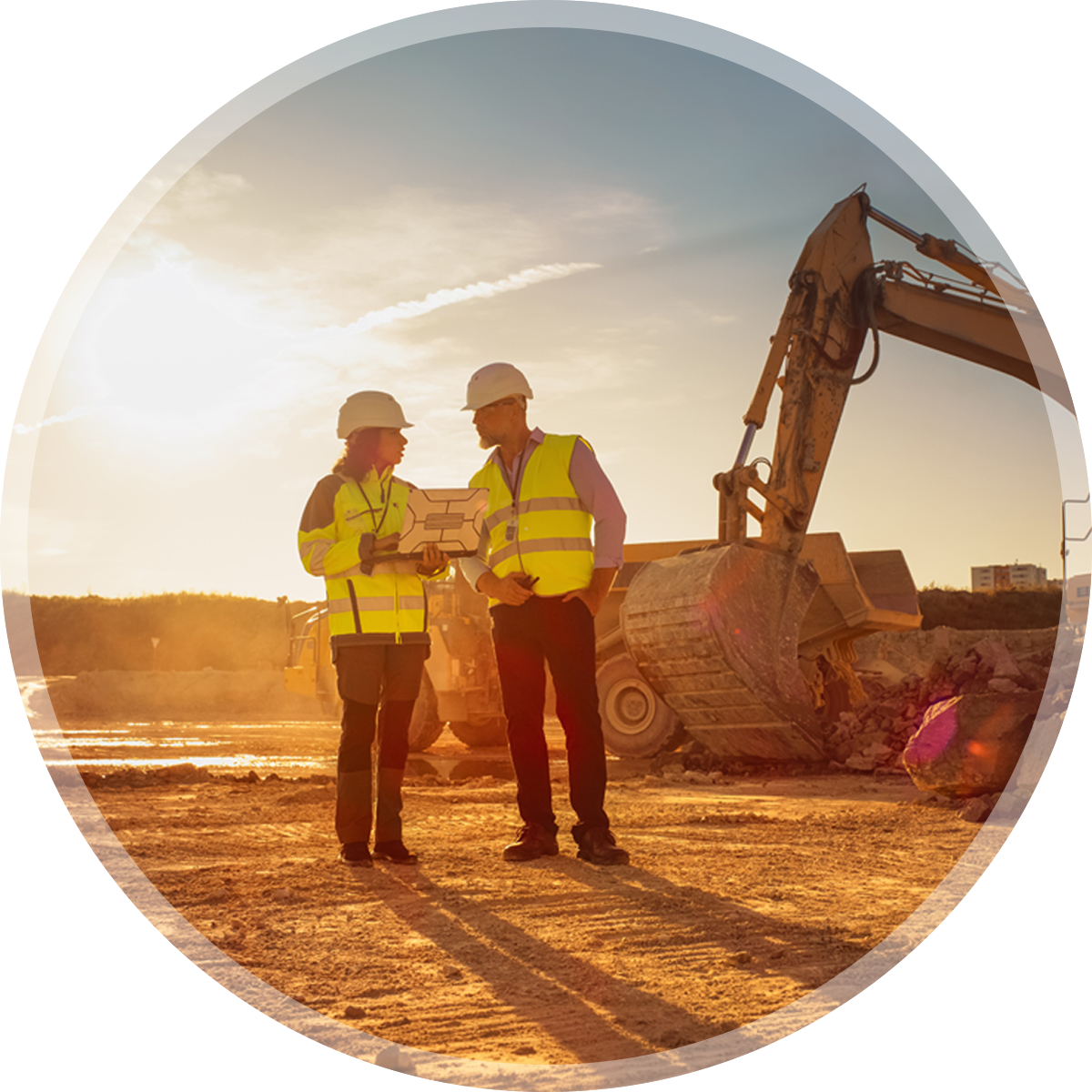Bauleiter und Bauleiterin besprechen Pläne auf Baustelle bei Sonnenuntergang